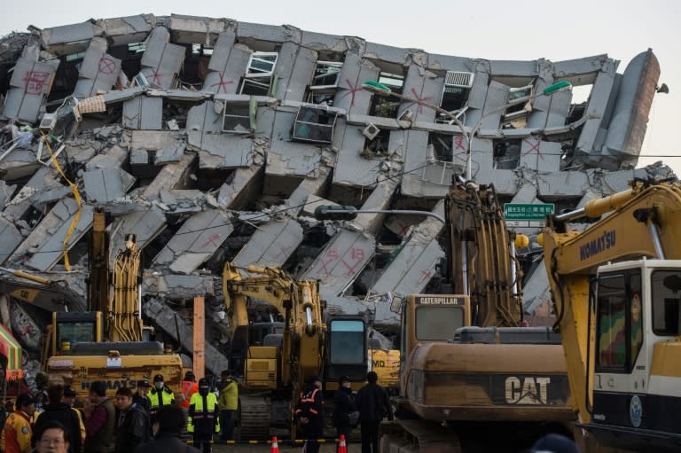 Excavator vehicles and rescue workers in front of the collapsed building in the southern Taiwanese city of Tainan