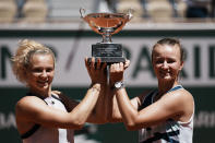 Czech Republic's Barbora Krejcikova, right, and compatriot Katerina Siniakova hold the cup after defeating USA's Bethanie Mattek-Sands and Poland's Iga Swiatek in their women's doubles final match of the French Open tennis tournament at the Roland Garros stadium Sunday, June 13, 2021 in Paris. (AP Photo/Thibault Camus)