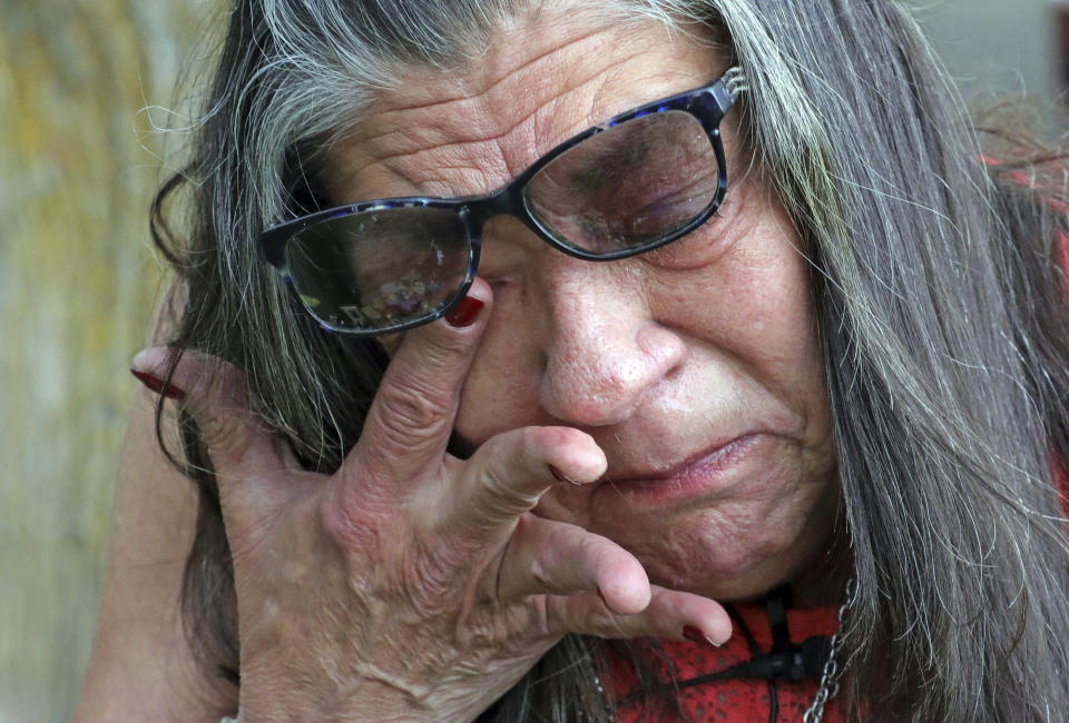 Melany Zoumadakis wipes a tear while visiting the grave of her daughter, Tanna Jo Fillmore, on Friday, April 26, 2019, in Salt Lake City. More than two years after her daughter's suicide, her mother says she still grieves and thinks about her constantly. Fillmore told her mother she desperately needed her prescription medicines, but a jail nurse wouldn't provide them. Her mother has filed sued. (AP Photo/Rick Bowmer)