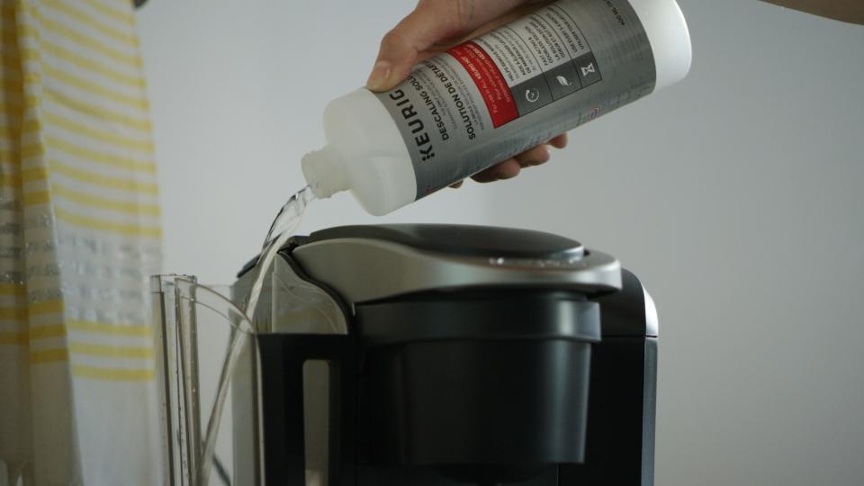 Descaler being poured into Keurig machine