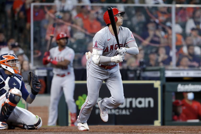 El bateador designado de los Angelinos de Los Ángeles Shohei Ohtani observa su cuadrangular junto al catcher Martin Maldonado en el duelo del domingo 25 de abril del 2021. (AP Photo/Michael Wyke)