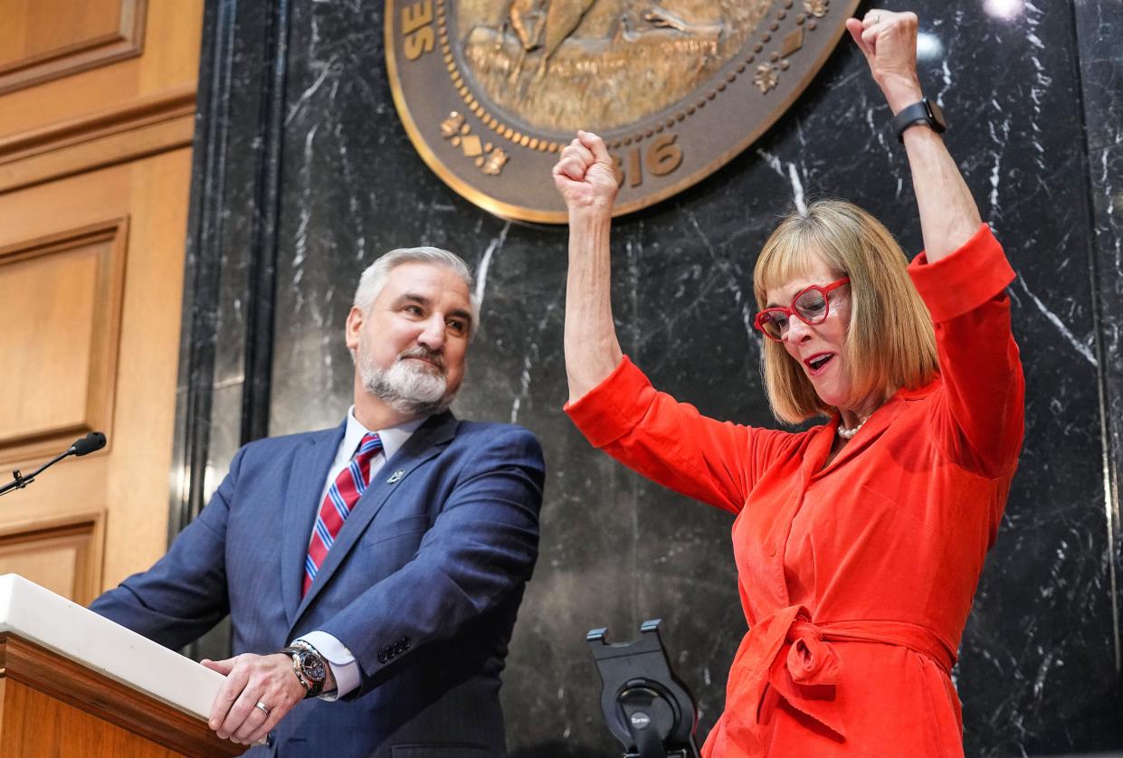 Gov. Eric Holcomb watches Lt. Gov. Suzanne Crouch cheer after announcing I-69 will be finished in 2024 connecting Indianapolis to Evansville on Tuesday, Jan. 9, 2024, during the State of the State address at the Indiana Statehouse in Indianapolis.