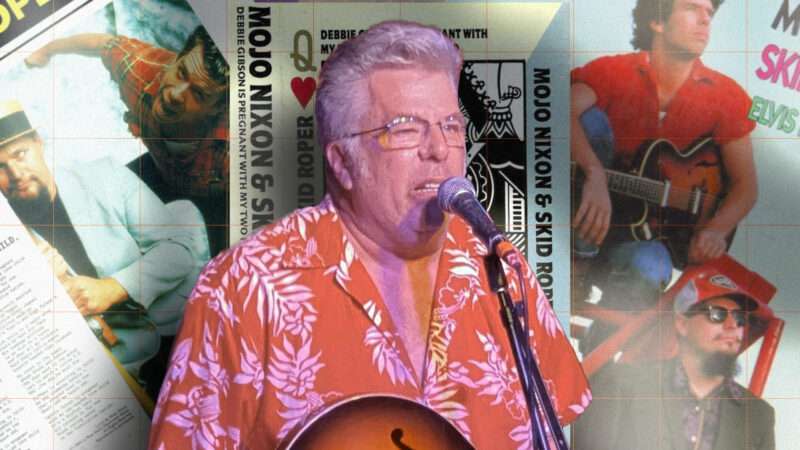 Mojo Nixon in 2022. In the background are three covers to his records.