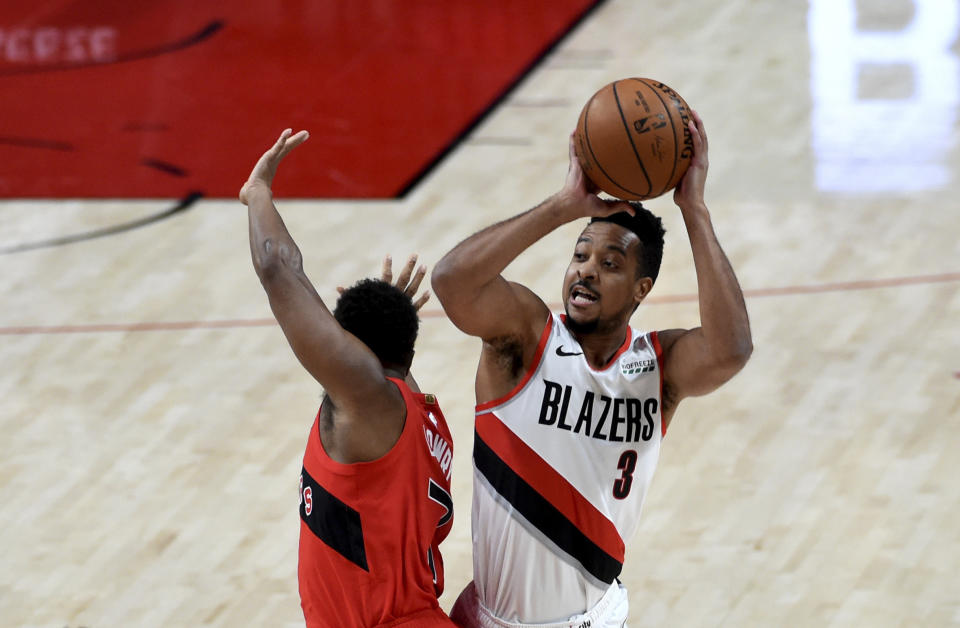 Portland Trail Blazers guard CJ McCollum, right, shoots over Toronto Raptors guard Kyle Lowry, left, during the first half of an NBA basketball game in Portland, Ore., Monday, Jan. 11, 2021. (AP Photo/Steve Dykes)