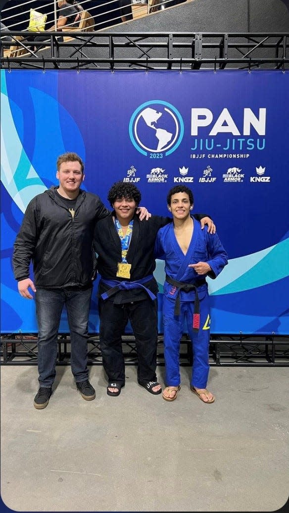 Brazilian jiu-jitsu practitioner Redding native Marcos Alvarado, 16, (center) is joined by his professor Tanner Rice (left) and older brother Mario Alvarado (right) after winning two gold medals at the Pan American IBJJF Championships in Kissimmee, Florida on Saturday, March 25, 2023.