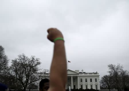 An anti-deportation demonstrator protests outside the White House in Washington, December 30, 2015. REUTERS/Carlos Barria