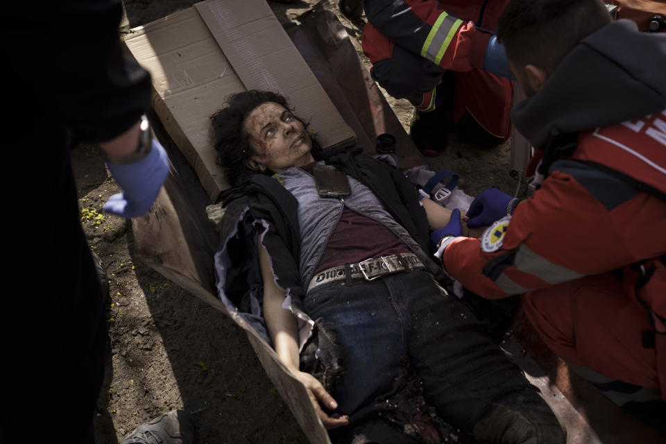 A woman injured in a Russian attack is treated by emergency workers in Kharkiv, Ukraine, Saturday, April 16, 2022. (AP Photo/Felipe Dana)