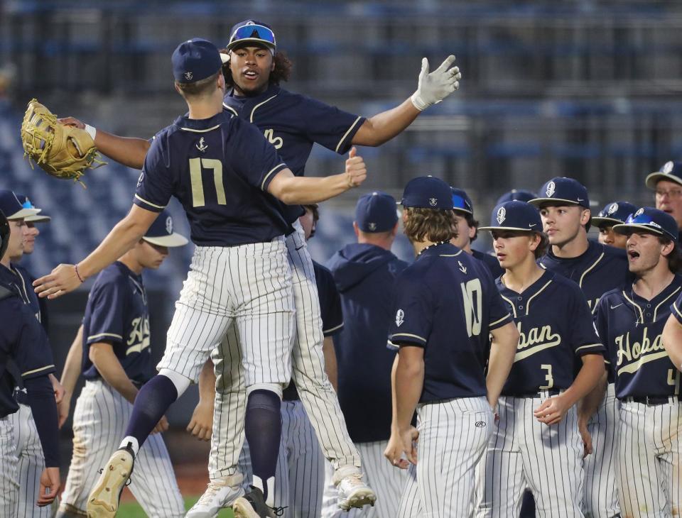 Hoban players Owen Turner and Justice Buckner celebrate defeating St. Vincent-St. Mary after the final out, Friday, May 10, 2024, at Canal Park.