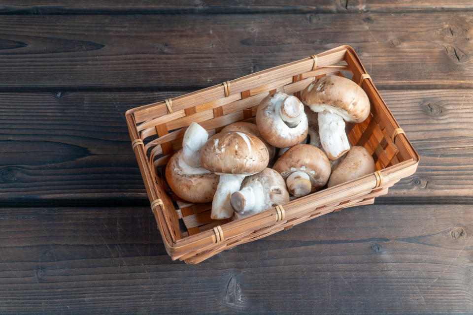 Mushrooms in a wicker basket on a table. 