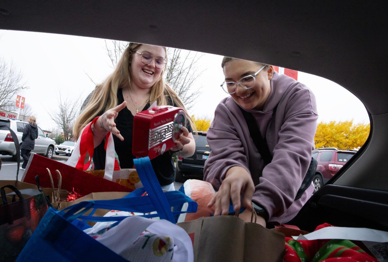 Audri Garner, left, and Olivia Staten load some of their Black Friday purchases during a trip to the Oakway Center in Eugene.