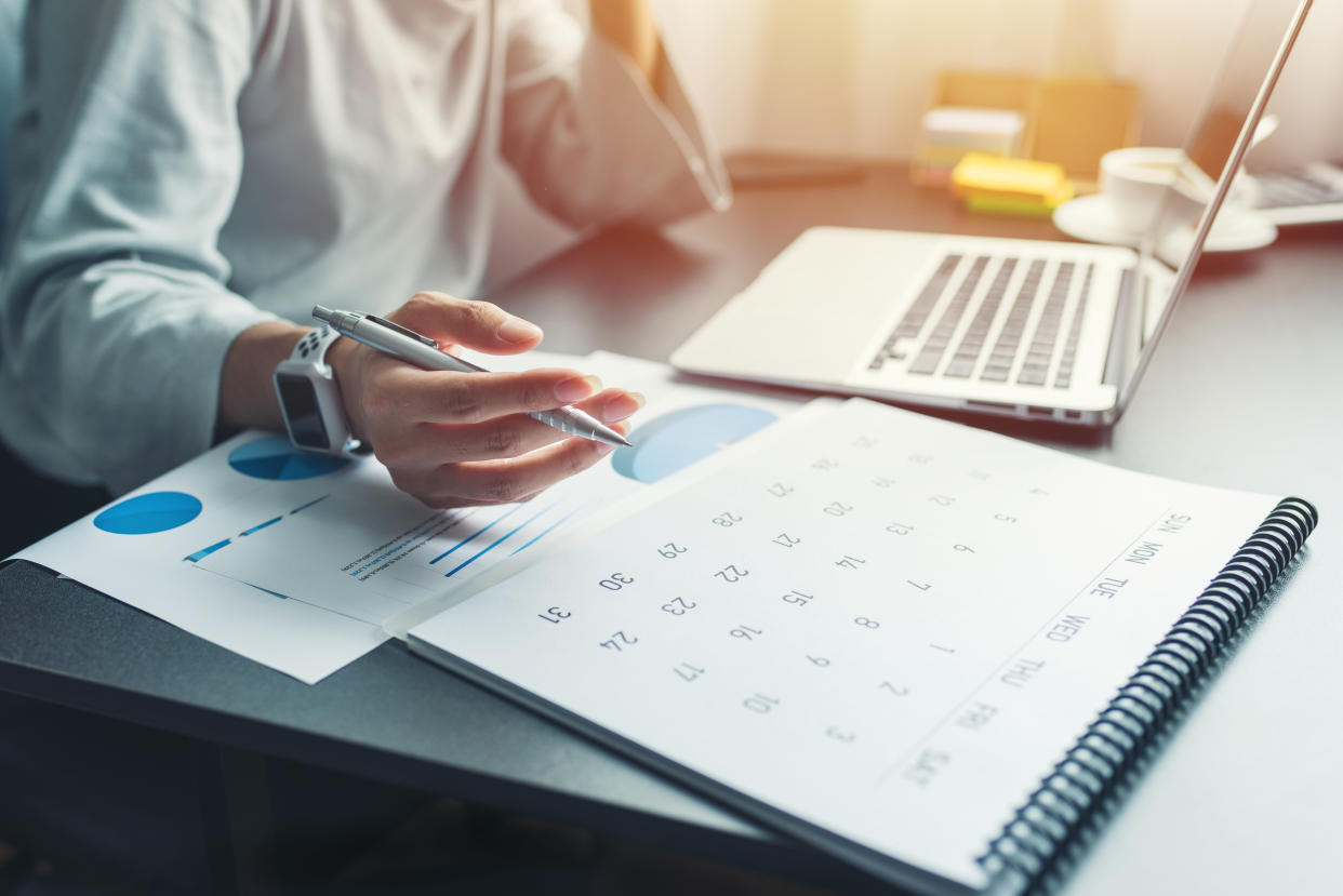 Business woman sitting working and thinking to planner event with calendar and laptop, computer on table at office or home or internet cafe.