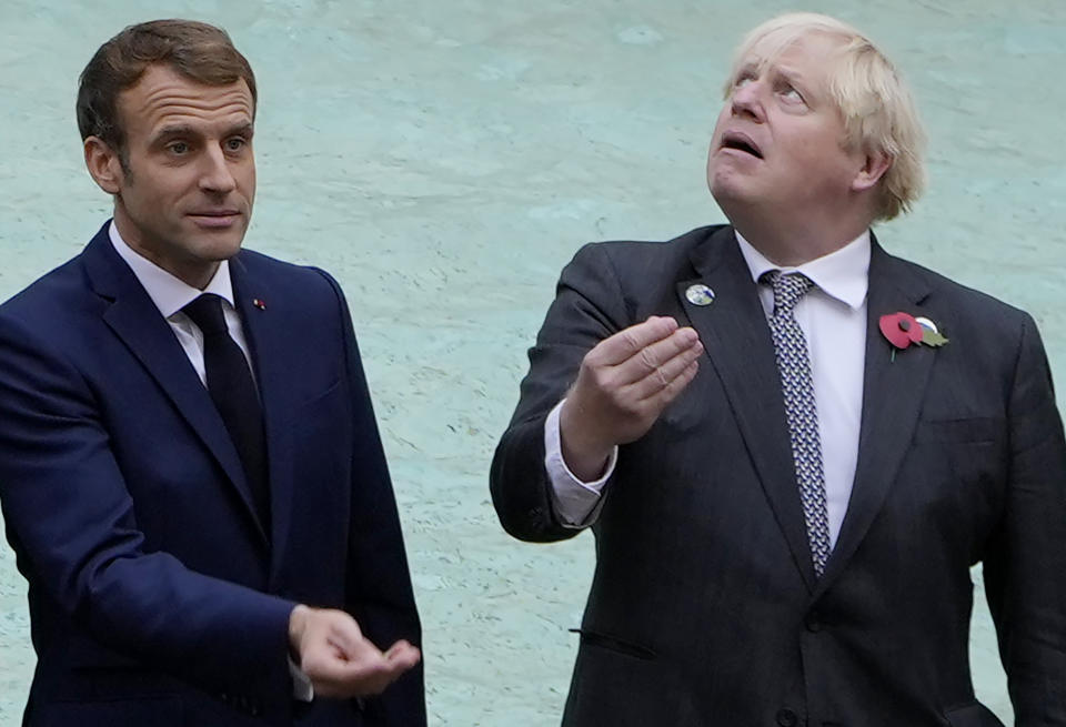 French President Emmanuel Macron, left, and British Prime Minister Boris Johnson prepare to throw a coin in the water at the Trevi Fountain during an event for the G20 summit in Rome, Sunday, Oct. 31, 2021. The two-day Group of 20 summit concludes on Sunday, the first in-person gathering of leaders of the world's biggest economies since the COVID-19 pandemic started. (AP Photo/Gregorio Borgia)