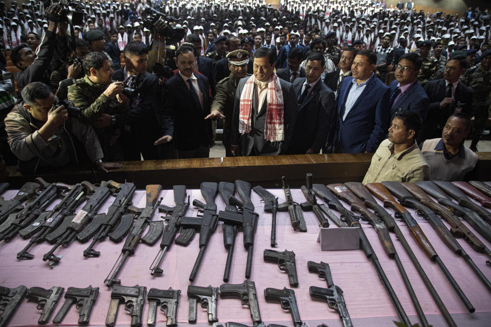 Assam state Chief Minister Sarbananda Sonowal, center, inspects arms and ammunition handed over by cadres of different rebel groups during a surrender ceremony in Gauhati, India, Thursday, Jan. 23, 2020. More than 600 insurgents belonging to eight different rebel groups have surrendered to Indian authorities in this troubled northeastern state, responding to the government’s peace initiative to rejoin mainstream society. (AP Photo/Anupam Nath)