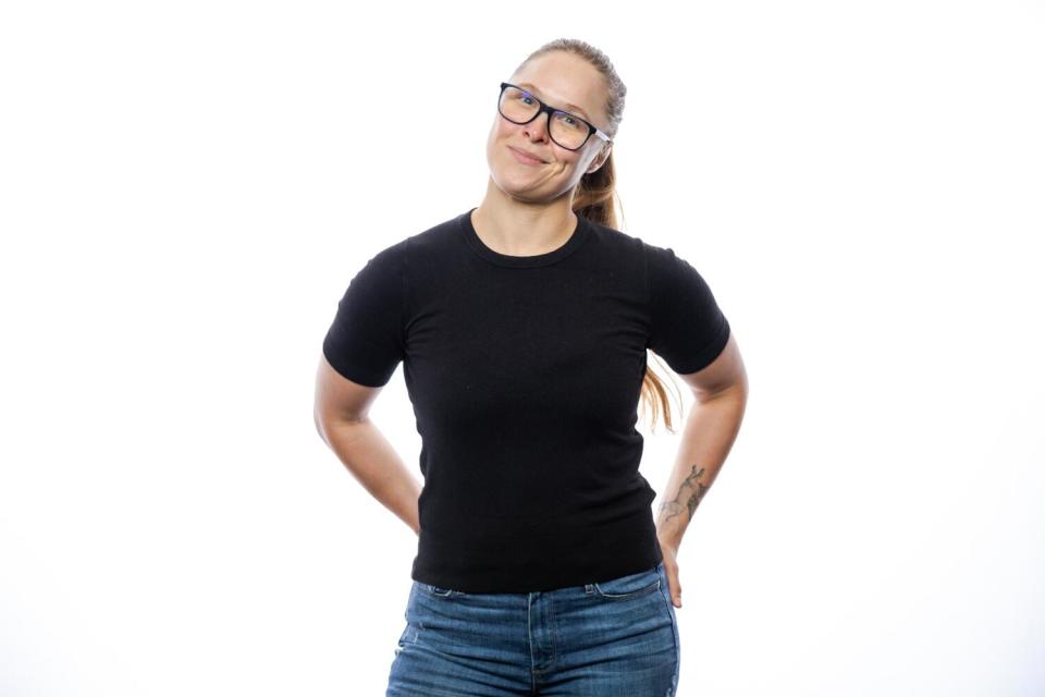 A woman stands with her head tilted.