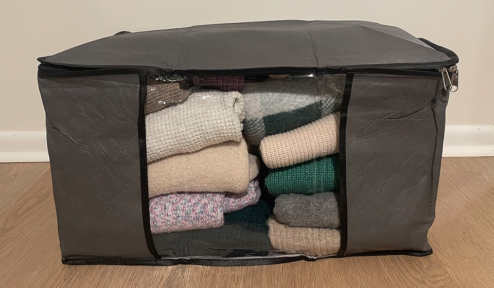 a fab totes foldable storage bag filled with sweaters