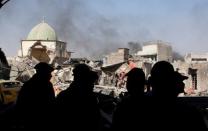 Members of Iraqi Counter Terrorism Service and the media are silhouetted in front of the ruins of Grand al-Nuri Mosque at the Old City in Mosul, Iraq June 29, 2017. REUTERS/Erik De Castro