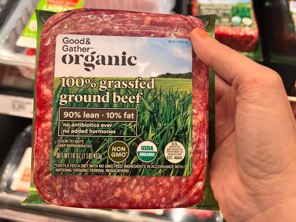 hand holding up a package of good and gather organic grass fed beef at target