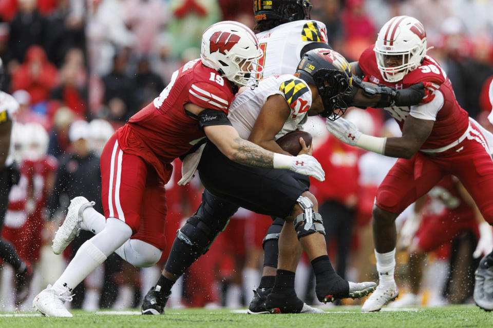 Nov 5, 2022; Madison, Wisconsin, USA; Wisconsin Badgers linebacker Nick Herbig (19) tackles Maryland Terrapins quarterback Taulia Tagovailoa (3) during the second quarter at Camp Randall Stadium. Mandatory Credit: Jeff Hanisch-USA TODAY Sports