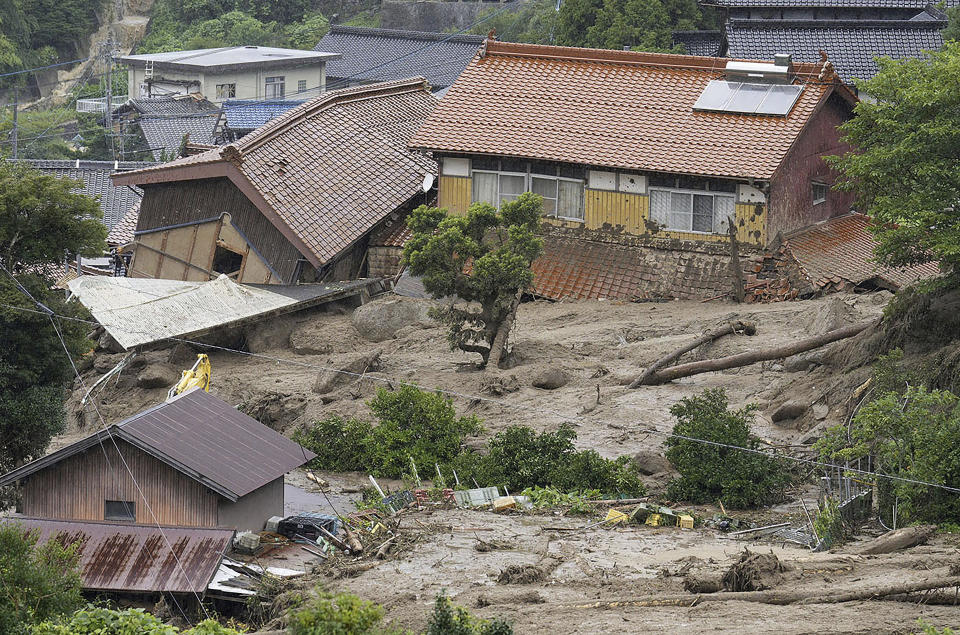 Houses are damaged by a landslide in Karatsu, Saga prefecture, southern Japan Monday, July 10, 2023. Torrential rain has been pounding southwestern Japan, triggering floods and mudslides. (Kyodo News via AP)