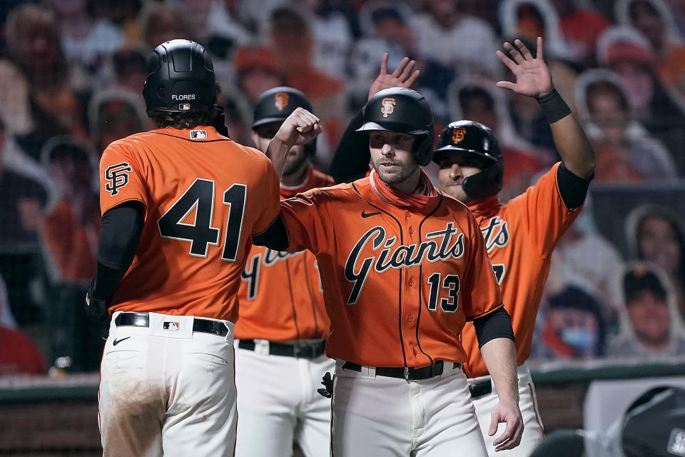 San Francisco Giants' Wilmer Flores (41) is congratulated by Austin Slater (13) and Donovan Solano, right, after hitting a three-run home run against the the San Diego Padres during the sixth inning of the second game of a baseball doubleheader Friday, Sept. 25, 2020, in San Francisco. (AP Photo/Tony Avelar)