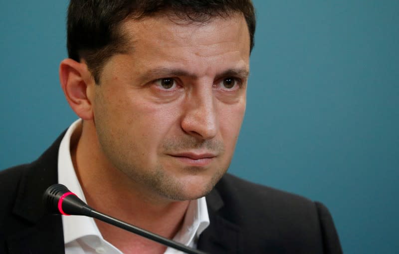 FILE PHOTO: Ukrainian President Volodymyr Zelenskiy reacts during a news conference in Kiev