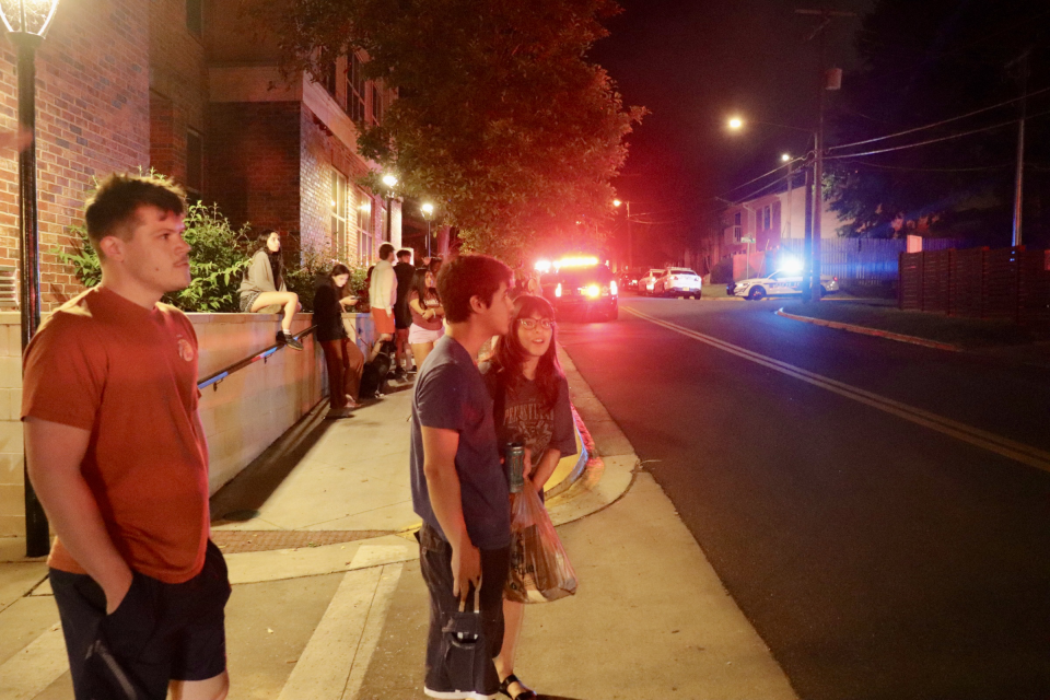 A crowd of dozens of onlookers watch as students evacuate a blaze at the Campus Row student housing complex on Carolina Street, just two blocks away from Florida State University's campus.