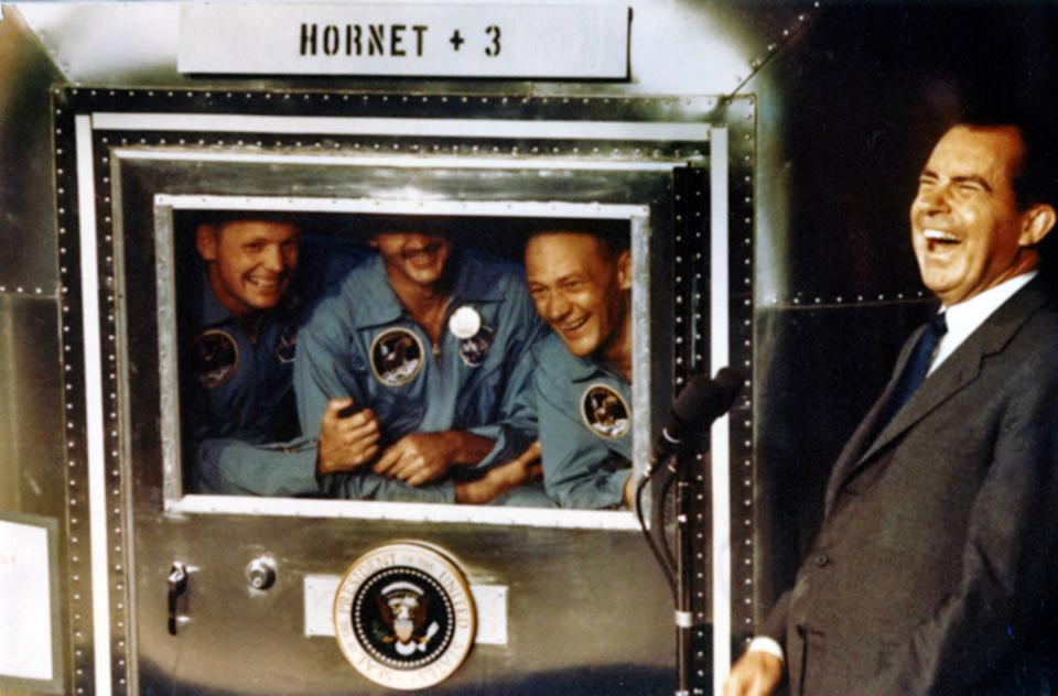 A July 24, 1969, photo provided by the Richard Nixon Foundation shows Apollo XI astronauts, from left, Neil Armstrong, Michael Collins and Buzz Aldrin laughing with President Richard Nixon aboard the USS Hornet. The president was on hand to greet the astronauts after their splashdown in the Pacific.