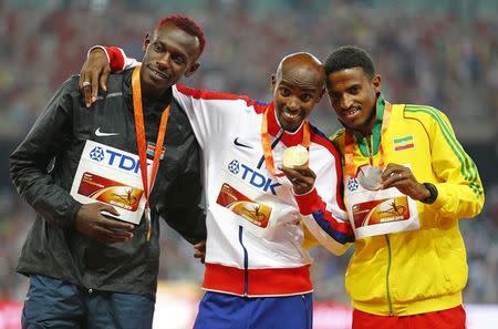 (L-R) Caleb Mwangangi Ndiku of Kenya, silver medal, Mo Farah of Britain, gold medal, and Hagos Gebrhiwet of Ethiopia, bronze medal, pose on the podium after the men's 5,000 metres event during the during the 15th IAAF World Championships at the National Stadium in Beijing, China, August 29, 2015. REUTERS/Damir Sagolj