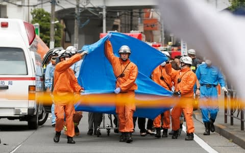 Rescuers work at the scene of an attack in Kawasaki, near Tokyo&nbsp; - Credit: AP