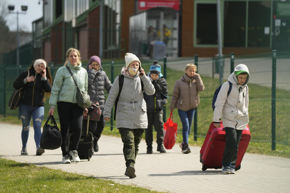 Refugees walk after fleeing the war from neighbouring Ukraine at the border crossing in Medyka, southeastern Poland, Tuesday, April 12, 2022. (AP Photo/Sergei Grits)