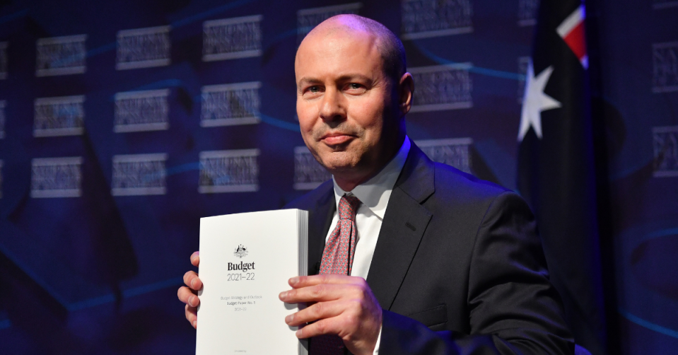 Treasurer Josh Frydenberg holds up the 2021 Budget