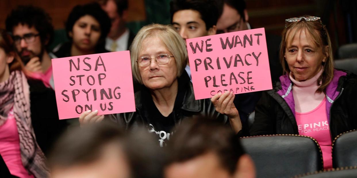 CodePink protesters hold signs in the audience as Richard Salgado, director of law enforcement and information security matters for Google, Inc, testifies before the Senate Judiciary Committee's Privacy , Technology, and the Law Subcommittee November 13, 2013 in Washington, DC.