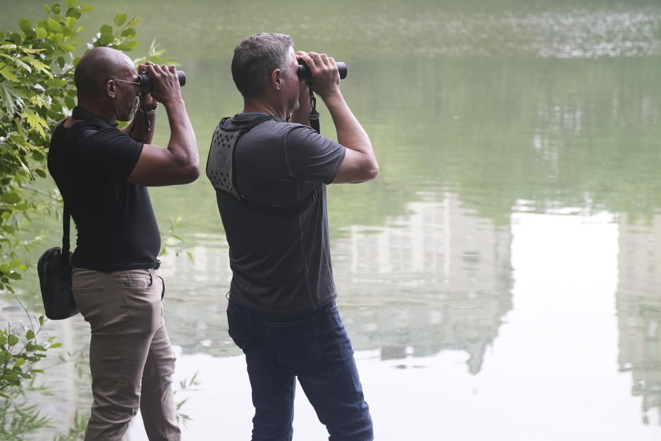 This image released by National Geographic shows Christian Cooper, left, and biologist- wildlife conservationist Jeff Corwin, lookin through binoculars across Central Park Lake in New York in a scene from “Extraordinary Birder with Christian Cooper." (National Geographic/Troy Christopher)