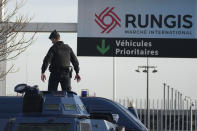A gendarme stands atop a military vehicle at the entrance of the Rungis International Market, which supplies the capital and surrounding region with much of its fresh food, Monday, Jan. 29, 2024 south of Paris. Protesting farmers intended to encircle Paris with barricades of tractors, aiming to lay siege to France's seat of power in a battle with the government over the future of their industry shaken by the repercussions of the Ukraine war. (AP Photo/Christophe Ena)