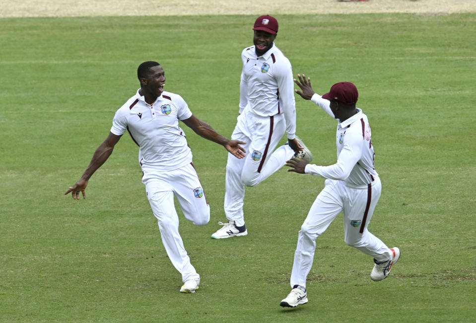 West Indies' Shamar Joseph, left, celebrates taking the wicket of Australia's Travis Head on the 4th day of their cricket test match in Brisbane, Sunday, Jan. 28, 2024. (Darren England/AAP Image via AP)