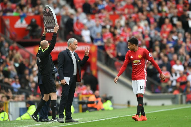 Manchester United's Portuguese manager Jose Mourinho (2L) gestures to Manchester United's English midfielder Jesse Lingard (R) on the touchline during the English Premier League football match between Manchester United and Leicester City