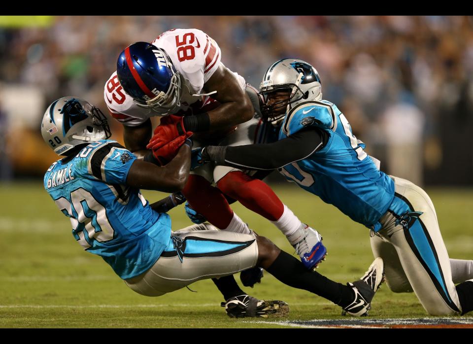 Martellus Bennett #85 of the New York Giants makes a reception in the first half against Chris Gamble #20 and James Anderson #50 of the Carolina Panthers at Bank of America Stadium on September 20, 2012 in Charlotte, North Carolina.  