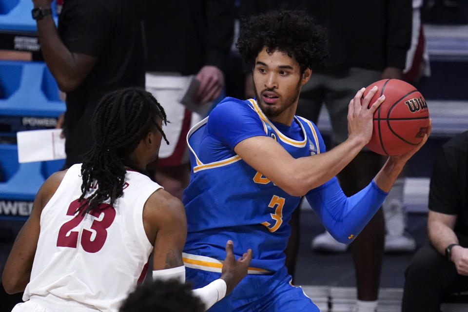 UCLA guard Johnny Juzang (3) protects the ball from Alabama guard John Petty Jr. (23) in the first half of a Sweet 16 game in the NCAA men's college basketball tournament at Hinkle Fieldhouse in Indianapolis, Sunday, March 28, 2021. (AP Photo/Michael Conroy)