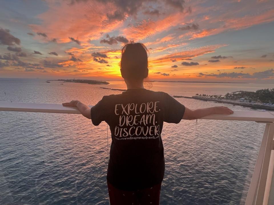 kari looking out at a sunset from a balcony of an all-inclusive resort