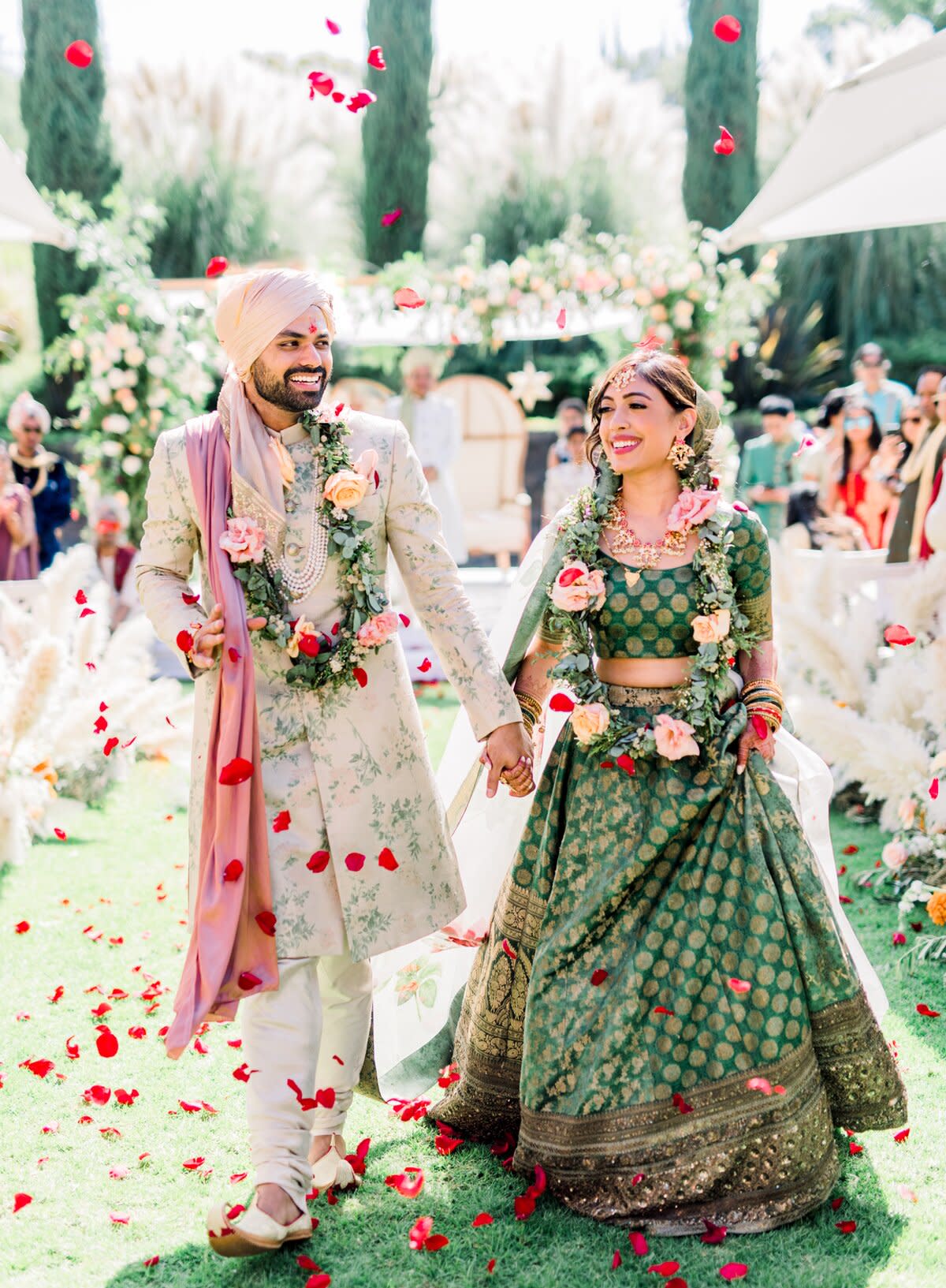 bride and groom walk down recessional aisle holding hands while smiling