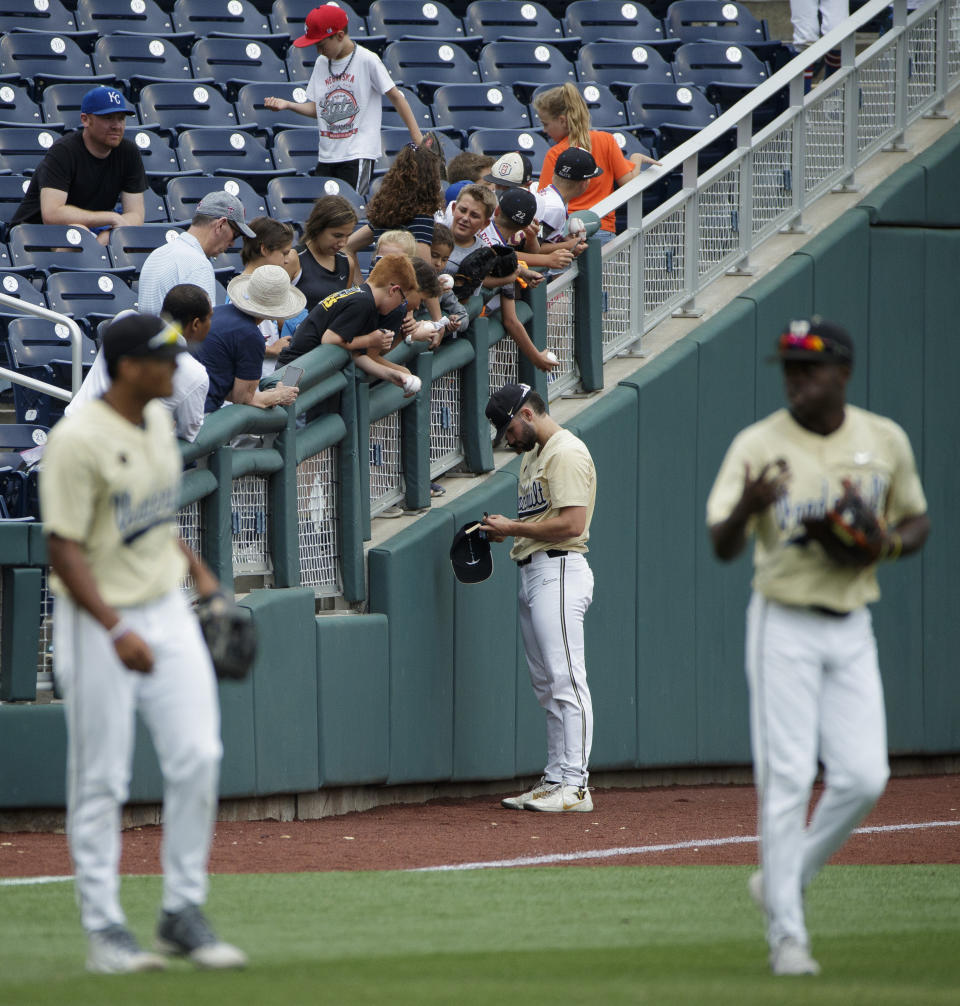 Vanderbilt's Jackson Gillis, back center, gives autographs to fans during practice for baseball's College World Series at TD Ameritrade Park, Friday, June 14, 2019, in Omaha, Neb. (Ryan Soderlin/Omaha World-Herald via AP)