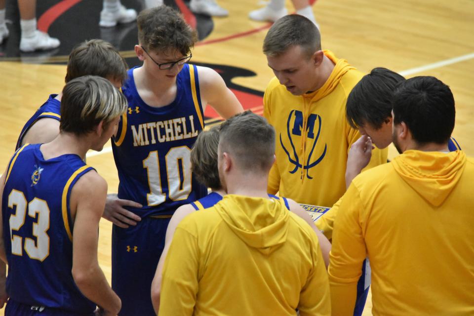 Mitchell boys' basketball coach Jackson Ryan speaks with his starting lineup ahead of the tip against Edgewood.