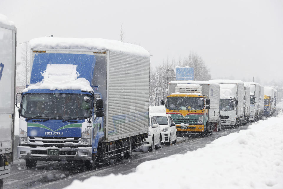 Cars get stuck on a road due to heavy snowfall Tuesday, Dec. 20, 2022 in Nagaoka, Niigata prefecture, northern Japan. (Miyuki Saito/Kyodo News via AP)