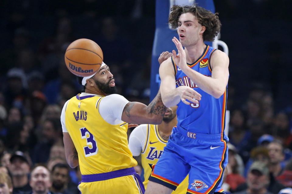 Oklahoma City Thunder guard Josh Giddey, right, passes the ball away from Los Angeles Lakers forward Anthony Davis (3) during the first half of an NBA basketball game, Thursday, Nov. 30, 2023, in Oklahoma City. (AP Photo/Nate Billings)
