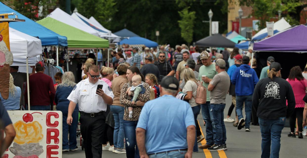 People check out the booths after the rain during the Cherry Blossom Festival on Main Street in Cherryville Saturday, April 22, 2023.