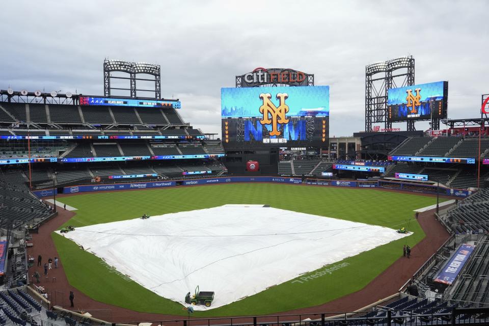 A tarp covers the infield at Citi Field as rain has delayed the start of a baseball game between the New York Mets and the Atlanta Braves, Friday, May 10, 2024, in New York. (AP Photo/Frank Franklin II)