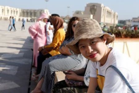 Chinese tourists sits at the esplanade of the Hassan II Mosque in Casablanca, October 6, 2016. REUTERS/Youssef Boudlal