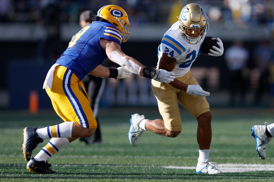 UCLA running back Zach Charbonnet (24) runs against California linebacker Jackson Sirmon (8) during the first half of an NCAA college football game in Berkeley, Calif., Friday, Nov. 25, 2022. (AP Photo/Jed Jacobsohn)