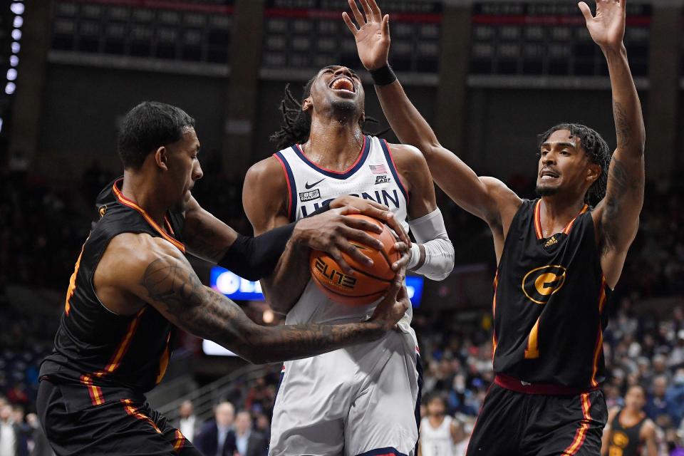 Grambling State's A.J. Taylor, left, fouls Connecticut's Isaiah Whaley, center, as Grambling State's Cam Christon, right, defends in the first half of an NCAA college basketball game, Saturday, Dec. 4, 2021, in Storrs, Conn. (AP Photo/Jessica Hill)