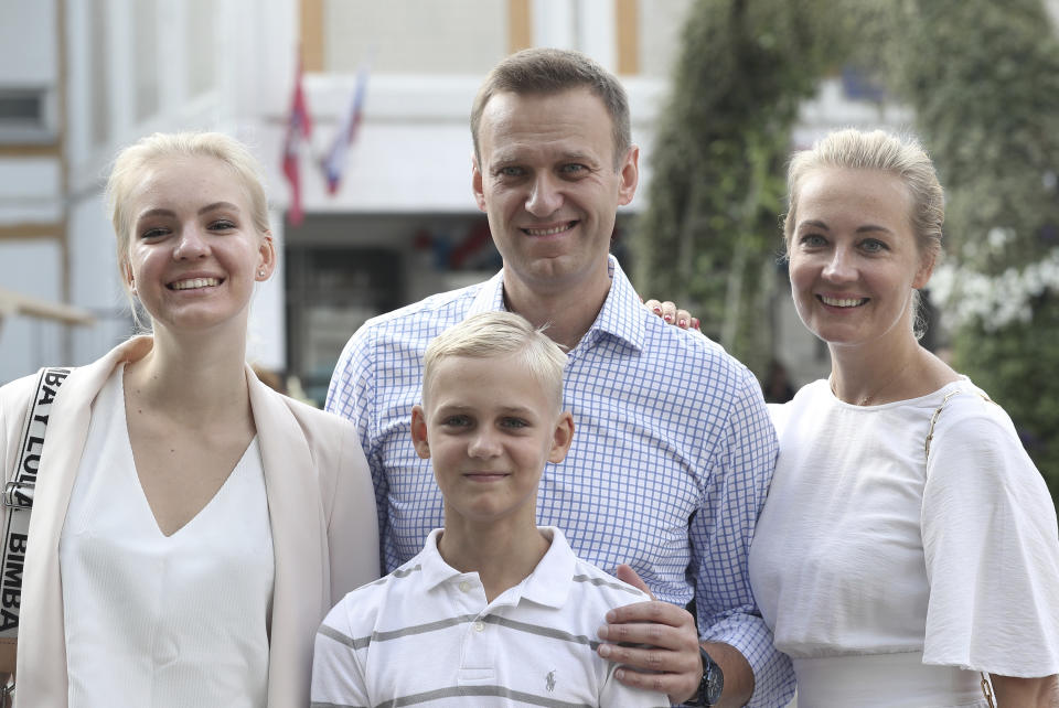 FILE - Russian opposition leader Alexei Navalny, with his wife Yulia, right, daughter Daria, and son Zakhar pose for media after voting during a city council election in Moscow, Russia, on Sunday, Sept. 8, 2019. In a span of a decade, Navalny has gone from the Kremlin's biggest foe to Russia's most prominent political prisoner. Already serving two convictions that have landed him in prison for at least nine years, he faces a new trial that could keep him behind for another two decades. (AP Photo/Andrew Lubimov, File)